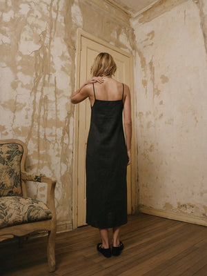 Back view of the ADELE black linen midi dress showing the straight neckline and spaghetti straps.