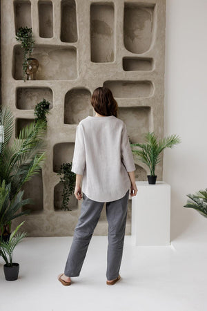 Back view of the grey Calyra linen tunic, showing the hip-length cut and drapey design.
