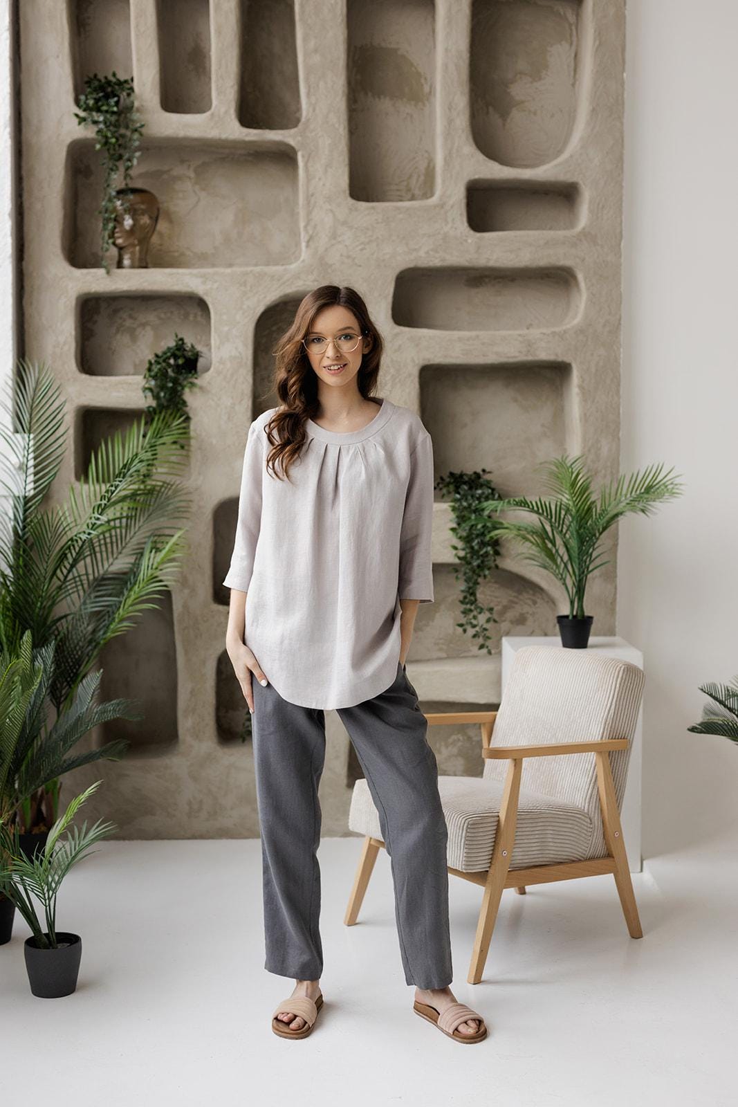 Full-length front view of a model wearing the Calyra light gray linen tunic, showing its relaxed fit and 3/4 sleeves.