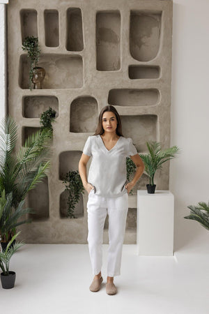 Woman posing with one hand in her pocket, showcasing the breathable and versatile linen V-neck top, perfect for effortless styling