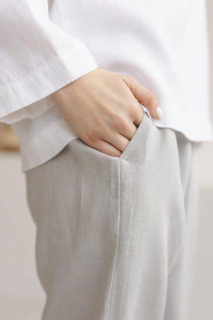Close-up of side pocket on dusty gray straight-leg linen pants, showing natural linen fabric texture