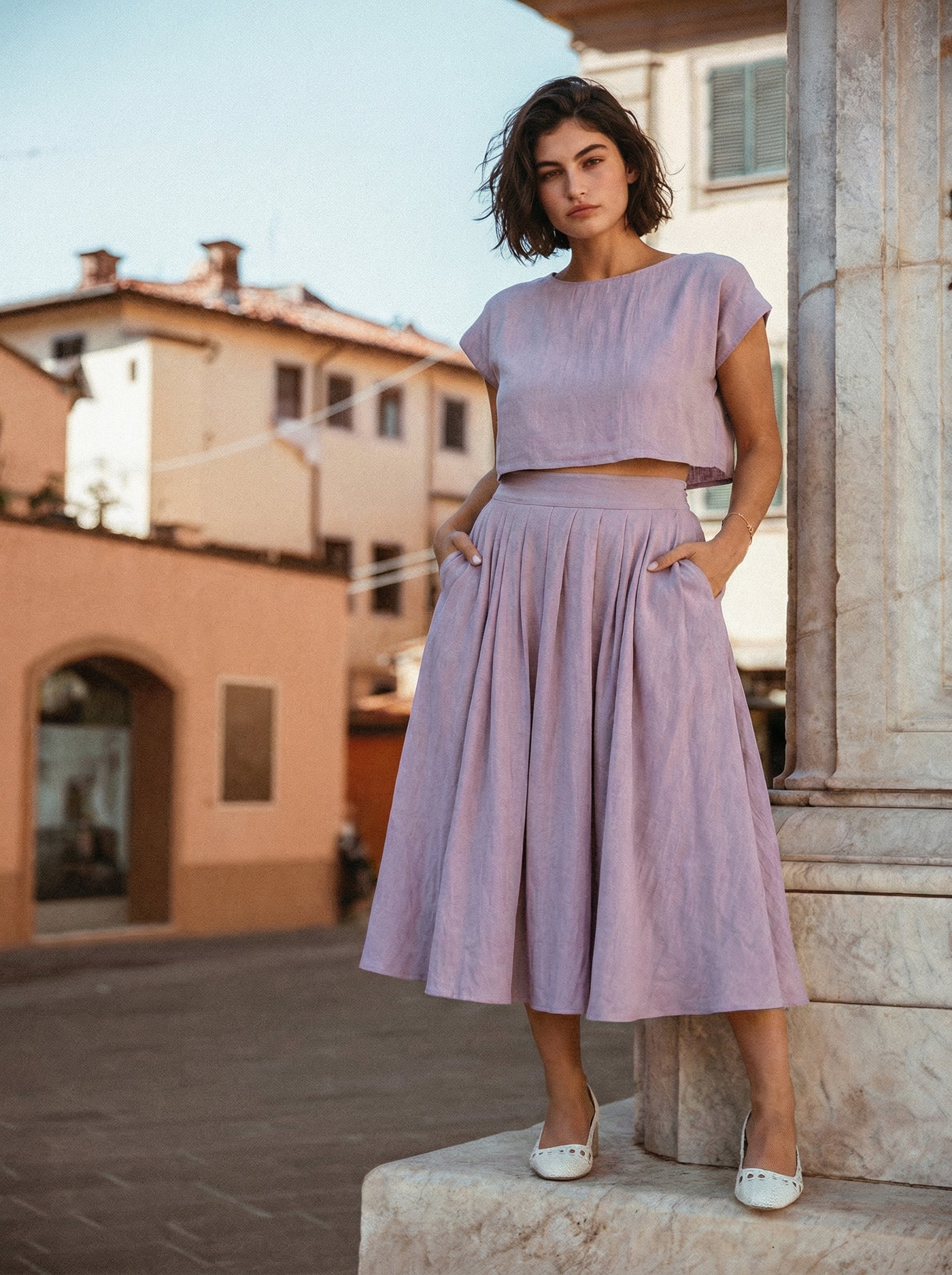 Sonfre NAOMI lilac linen two-piece set, featuring a short boxy top and a high-waisted midi skirt with pockets, standing on a boat.