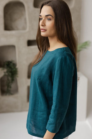 Close-up, soft breathable 100% linen fabric, natural texture, teal green blouse detail.