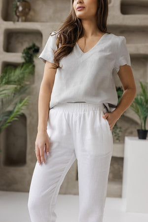 Detailed close-up of elastic waist white linen pants, showing the natural linen texture and functional side pockets for casual and comfortable wear