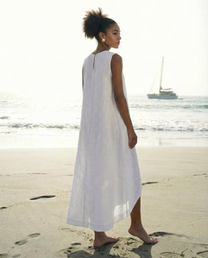 Back view of a sleeveless white linen dress showing the asymmetrical high-low hemline and keyhole detail.