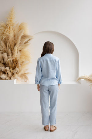 Back view of relaxed-fit dusty blue linen pants with an elastic waistband, highlighting the straight-leg design and lightweight linen fabric.