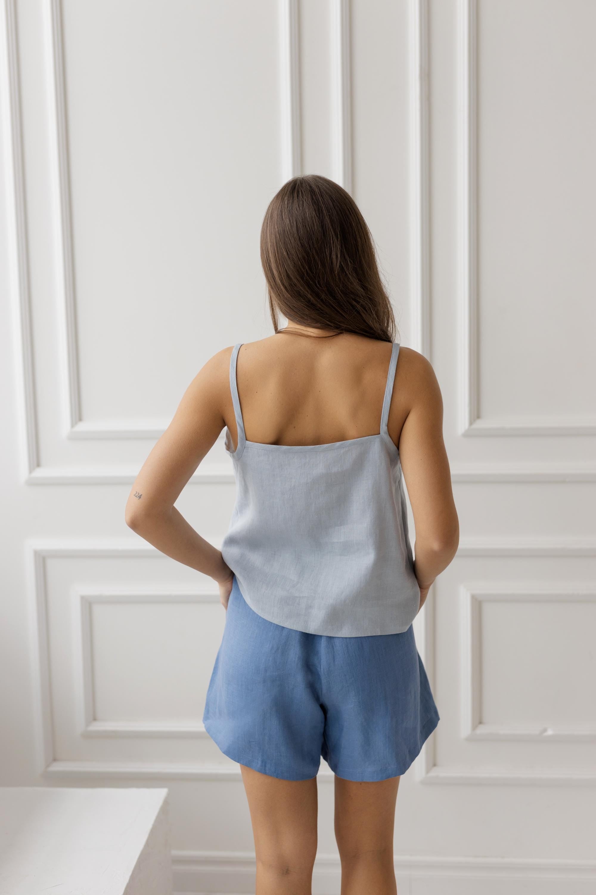 Back view of denim blue linen shorts with a light blue camisole, showing the comfortable fit and lightweight linen fabric.