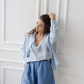 Model wearing denim blue linen shorts with an elastic waistband and relaxed fit, styled with a light blue top.