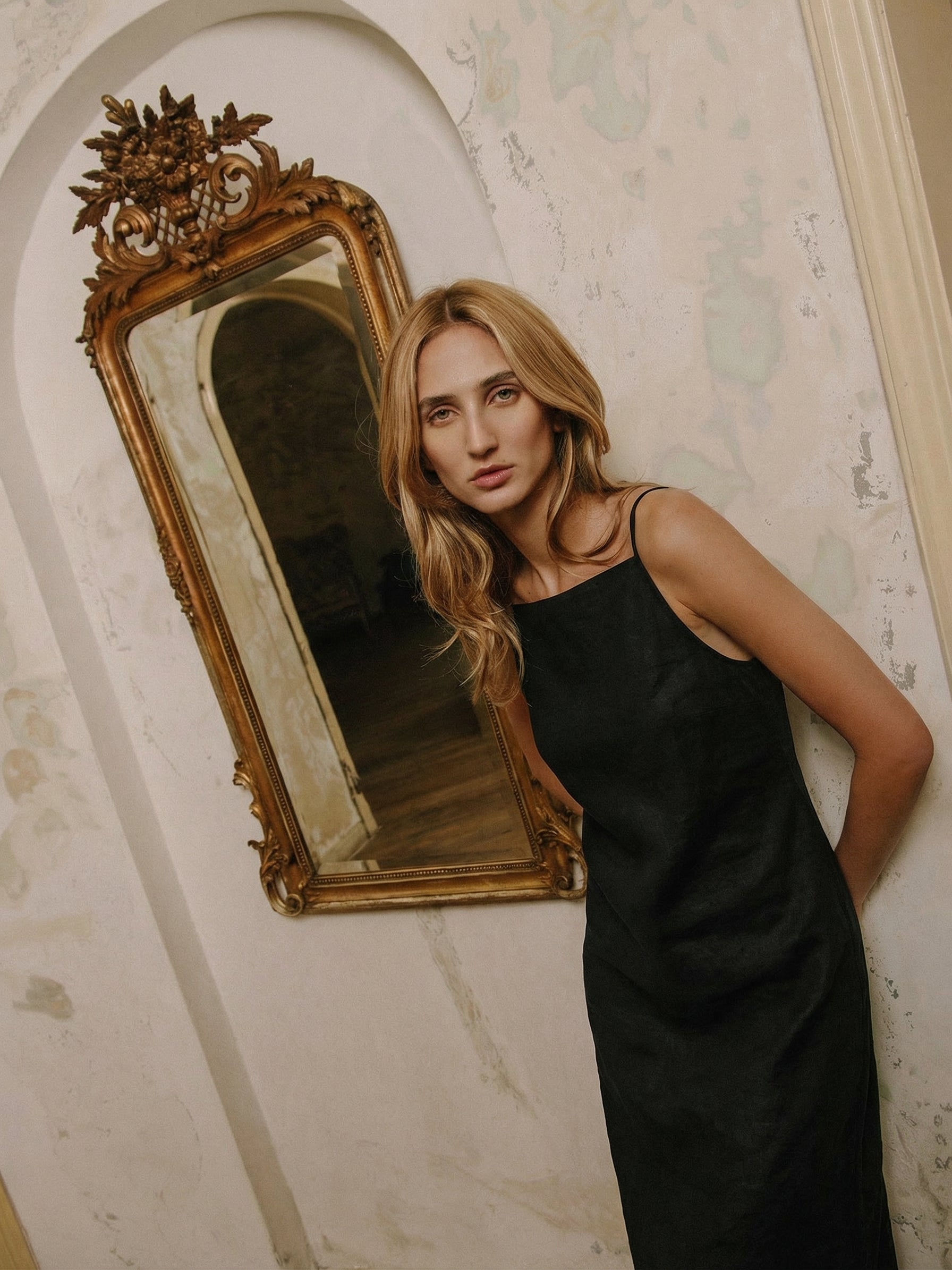 A simple black linen slip dress with thin straps and a midi length.