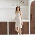 Off-white linen nightdress, front view, spaghetti straps, minimalist style.