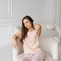 Model in ash pink linen tank top, sitting, comfortable summer wear.