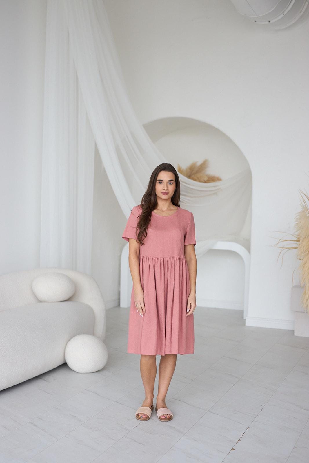 Close-up of blush salmon linen fabric; lightweight texture, soft drape, and fabric movement.