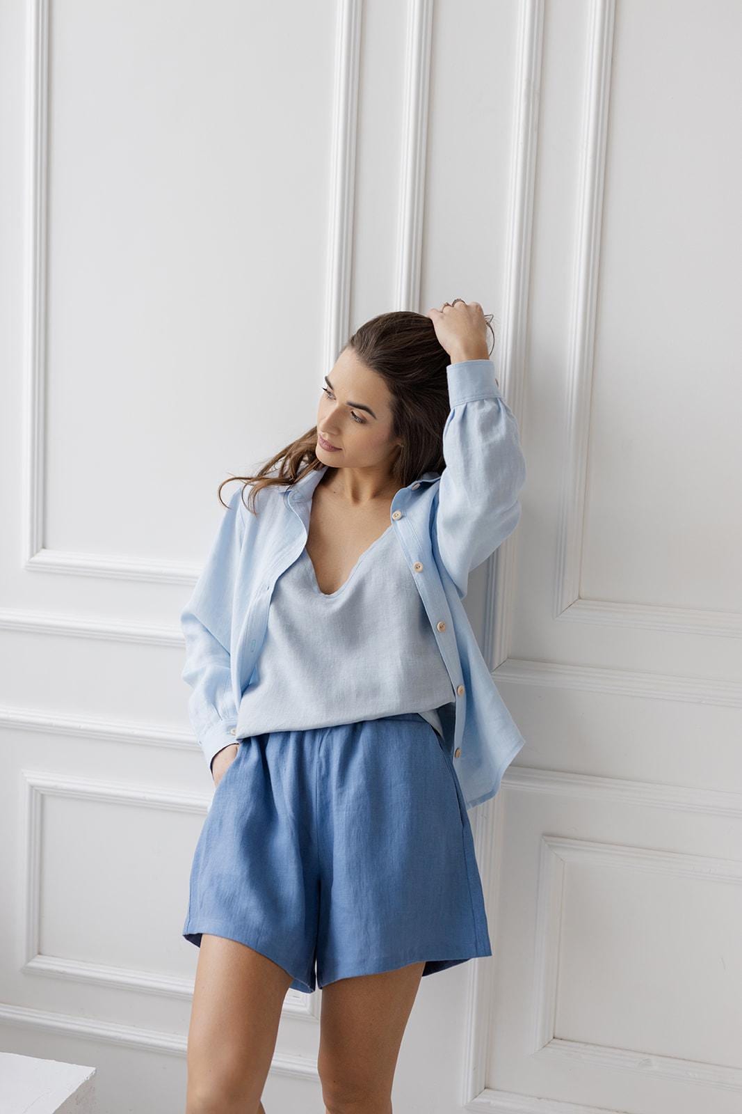 Model in ice blue linen shirt, wooden buttons, casual summer style.