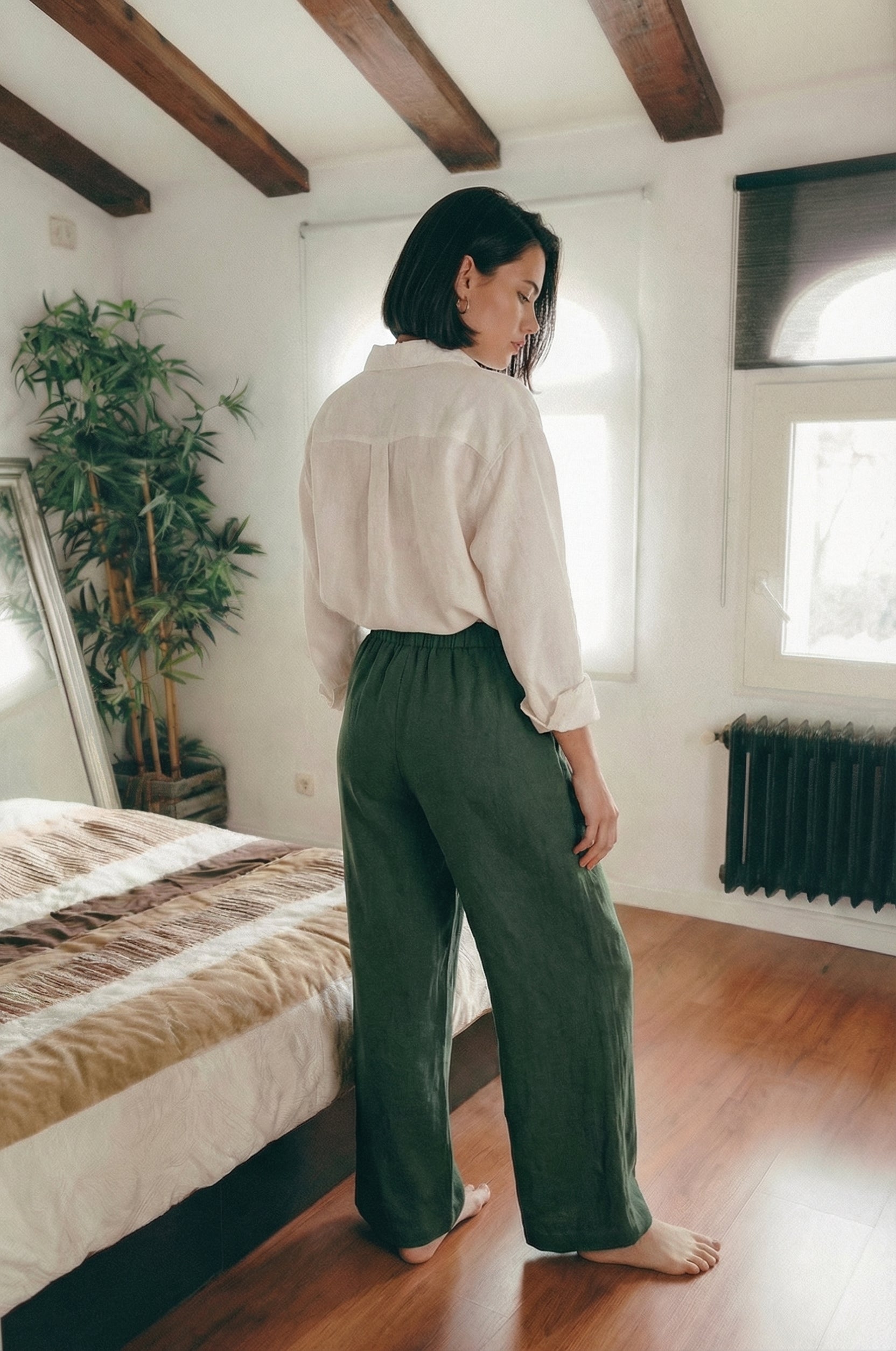 Back view of a woman wearing MINA smoke pine wide leg linen pants, showing the flattering drape and comfortable fit from behind.
