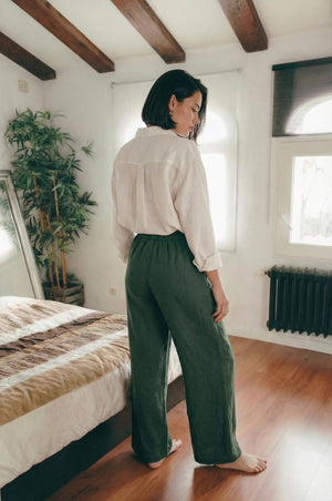 Back view of a woman wearing MINA smoke pine wide leg linen pants, showing the flattering drape and comfortable fit from behind.