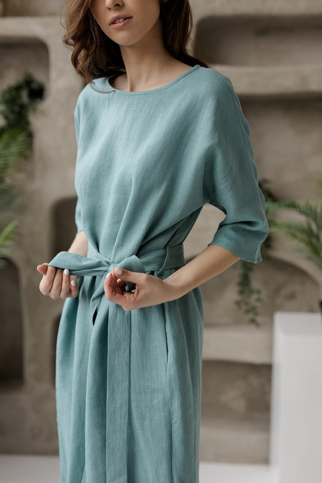 Adjustable tie belt detail on linen tunic dress, minimalist design.