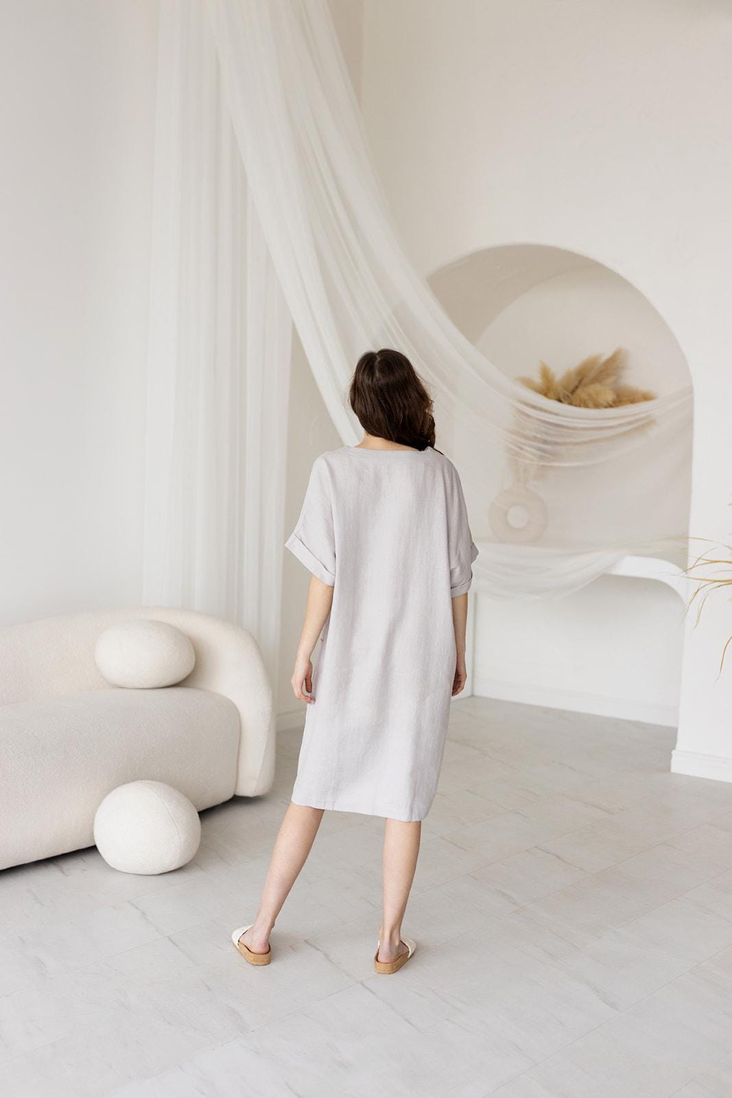 Back view of a mid-length linen dress with a straight-cut fit, relaxed drape, and minimalist design. Soft, airy, and comfortable for warm-weather wear.