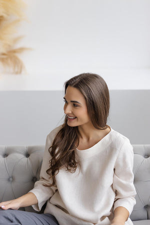 Close-up: off-white medium-weight linen blouse fabric texture.