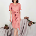 Flattering blush linen midi wrap dress by SonFre, featuring a V-neckline, short sleeves, adjustable tie belt, and a classic wrap design, perfect for summer style.