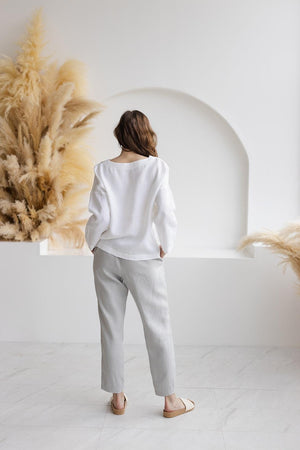 Back view of Solvia white linen blouse, relaxed fit, wide sleeves, seamless design, medium weight linen drape.