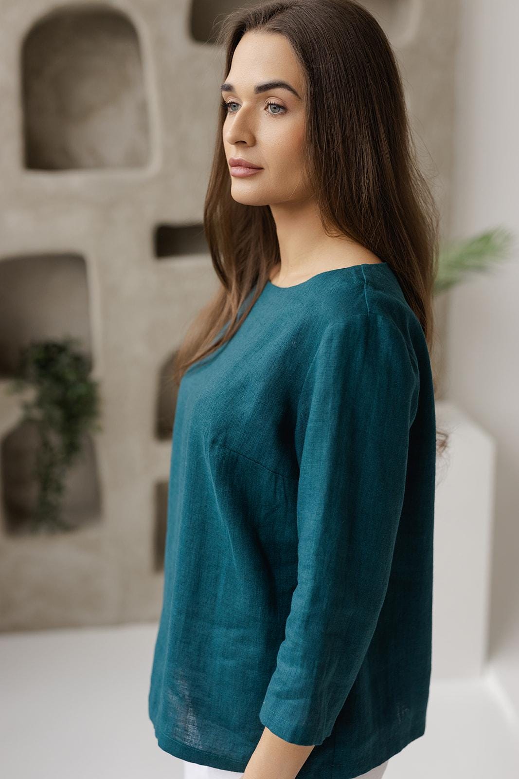 Close-up, soft breathable 100% linen fabric, natural texture, teal green blouse detail.