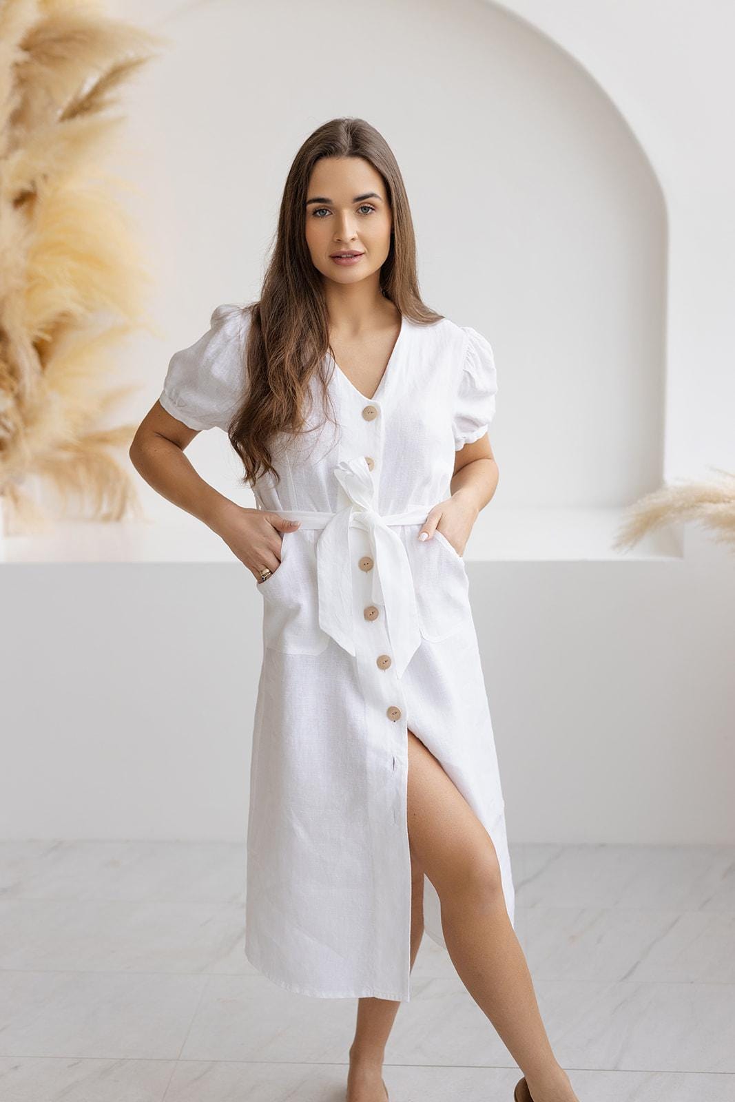 White linen button-down dress with puff sleeves, A-line silhouette, and natural wooden buttons, ideal for summer fashion.