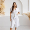 Model wearing a white puff sleeve linen midi dress with a button-down front and tie waist, showcasing a casual summer look.