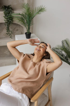 Flat-lay of a taupe boxy linen blouse, neatly folded to showcase its minimalist design, relaxed fit, and breathable fabric. A timeless and versatile women’s top made from premium natural linen.