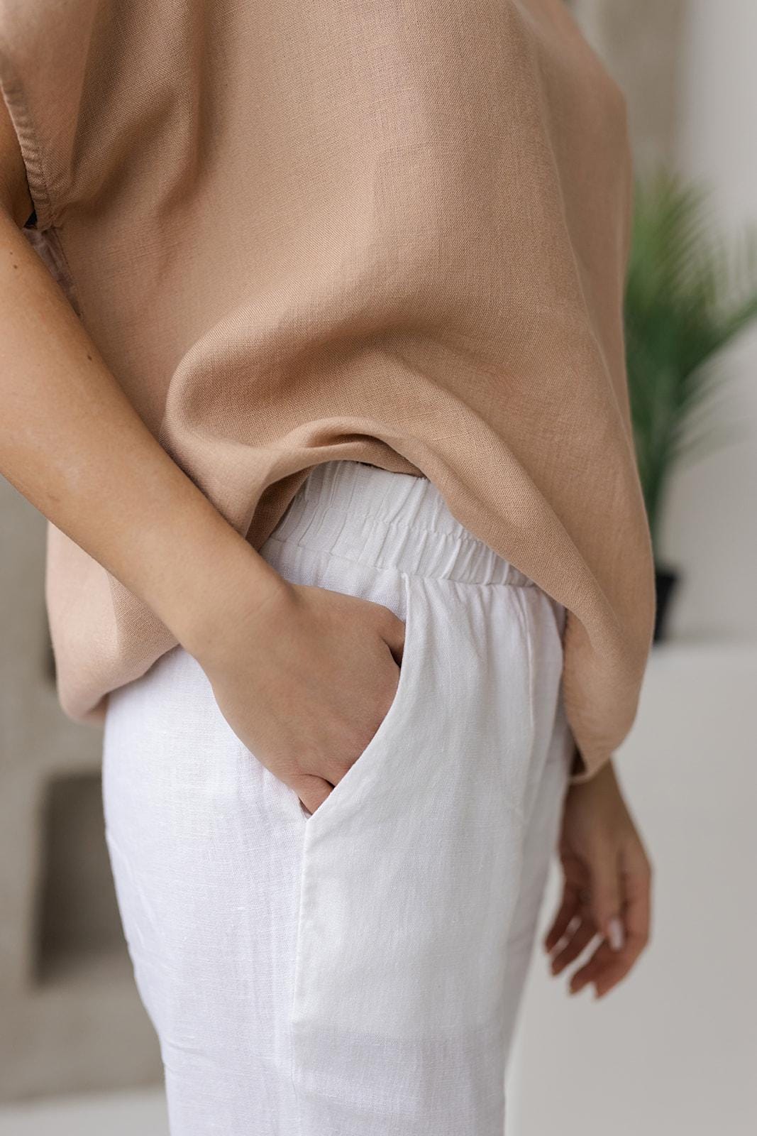 Close-up of natural taupe linen fabric, showcasing its breathable texture and soft, medium-weight quality. Made from 100% linen, perfect for a comfortable and eco-friendly wardrobe.