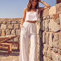 Model wearing the TORA white linen cropped top featuring a square neckline and thick straps.