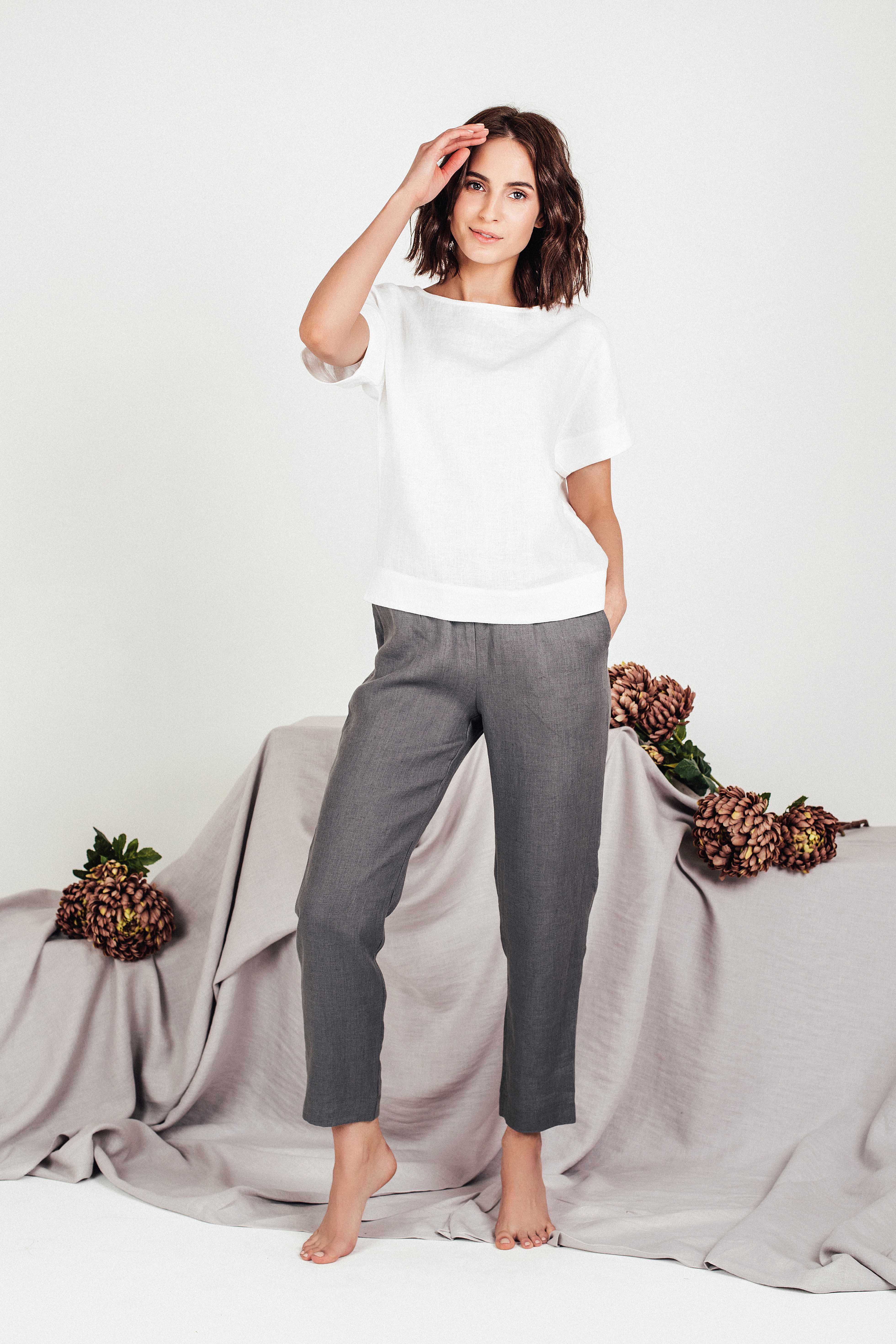 Close-up detail of white linen fabric and boat neckline on SORA boxy top