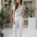 White linen pants styled with a gray linen blouse in a modern, minimalist room, perfect for summer, vacation, or casual everyday wear
