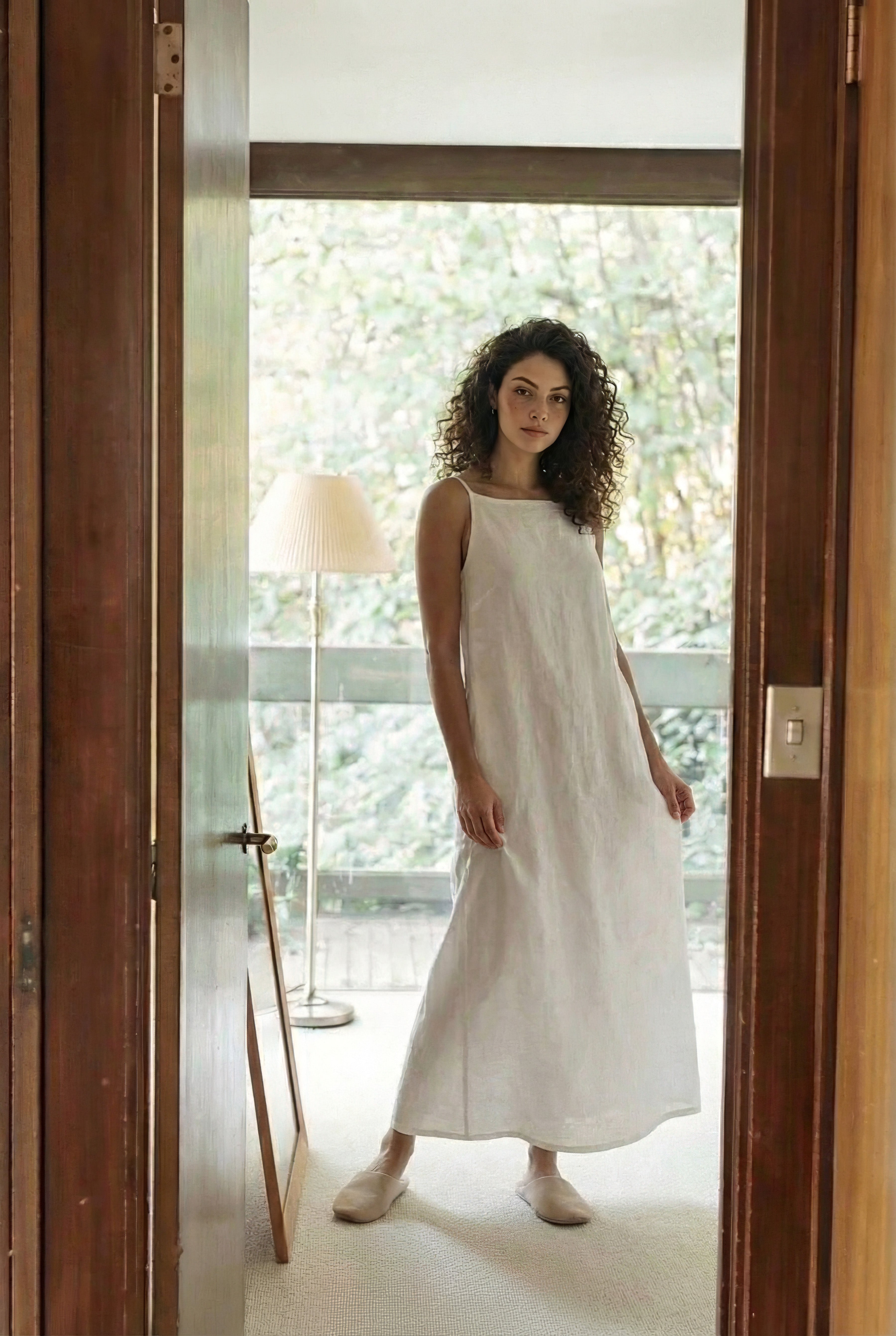 Full length view of white linen slip dress showing flowy fabric texture and comfortable relaxed fit.