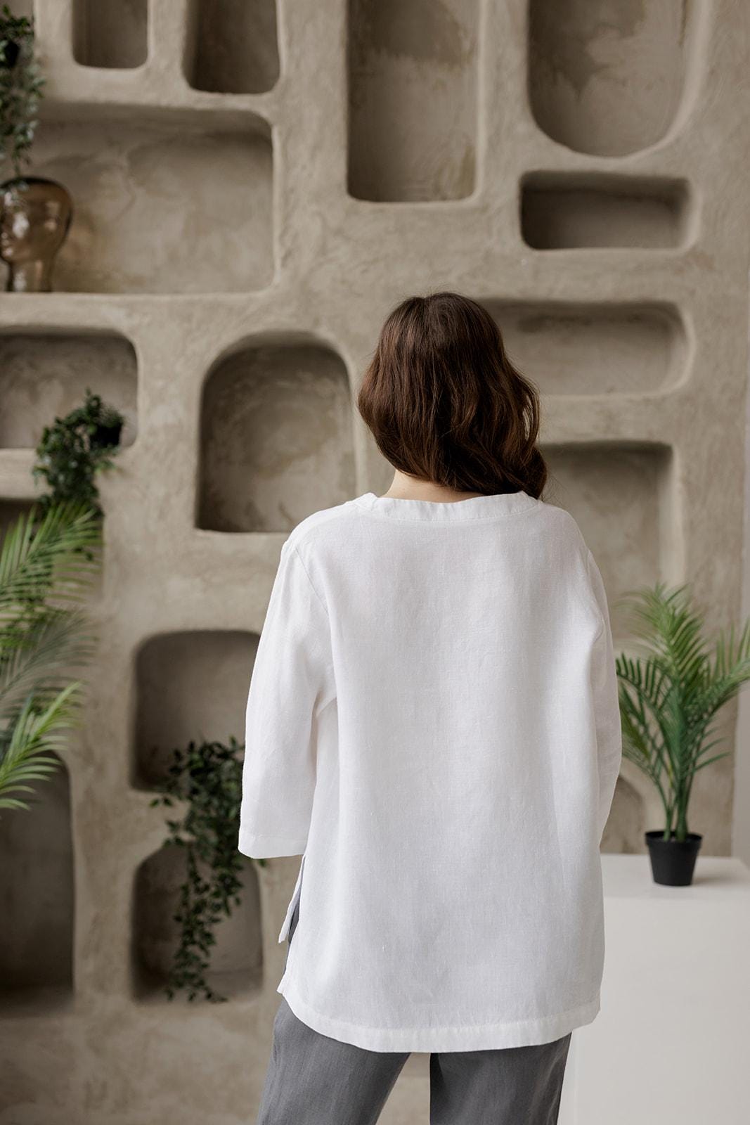 Back view: oversized white linen tunic. Relaxed drape, natural linen fabric.