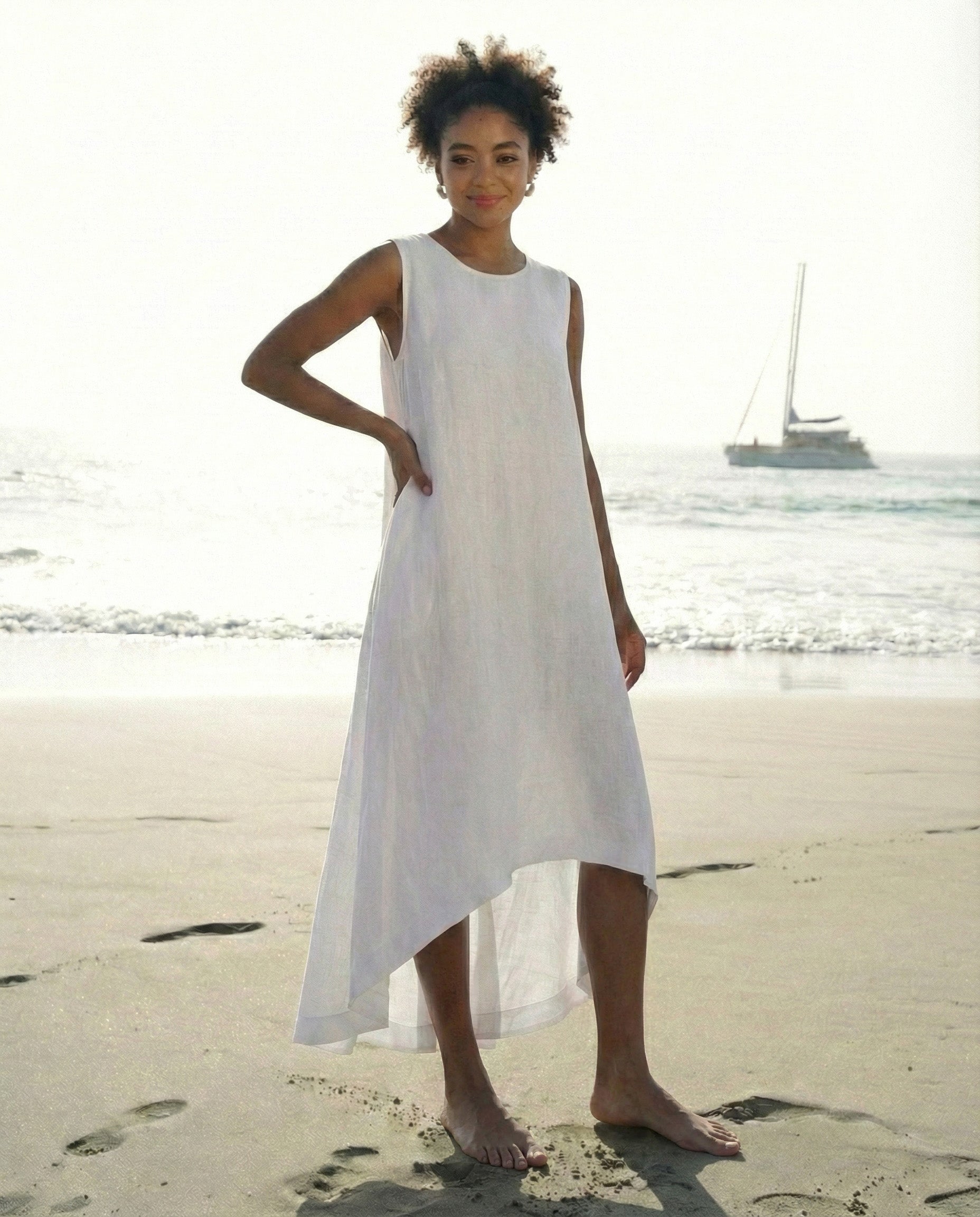 Front view of a relaxed-fit white linen A-line dress with a modern high-low hemline.